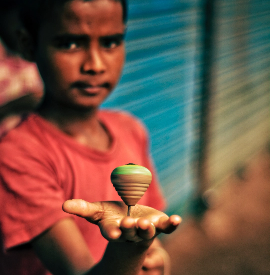 A small boy playing with a top.