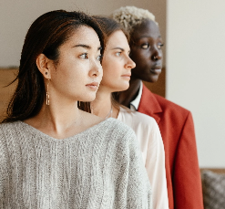 Three different women from different races and colors standing next to each other.