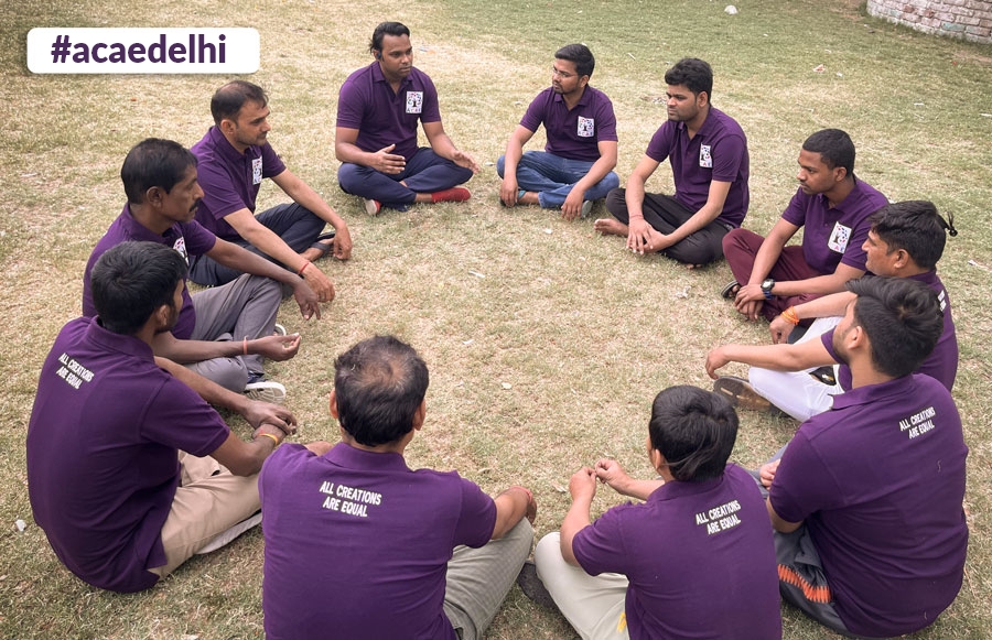 A group of ACAE Delhi volunteers discussing in a park.