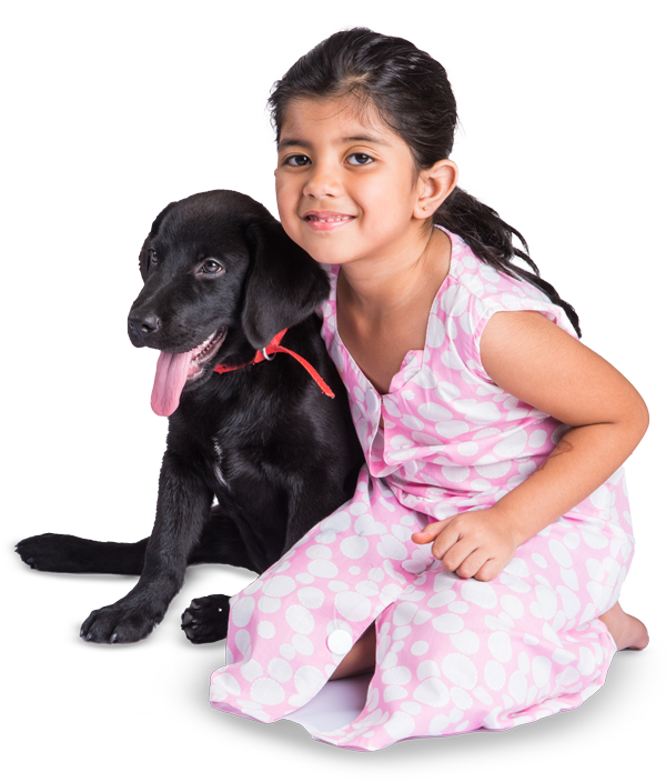 A small girl hugs and cares for a black dog.
